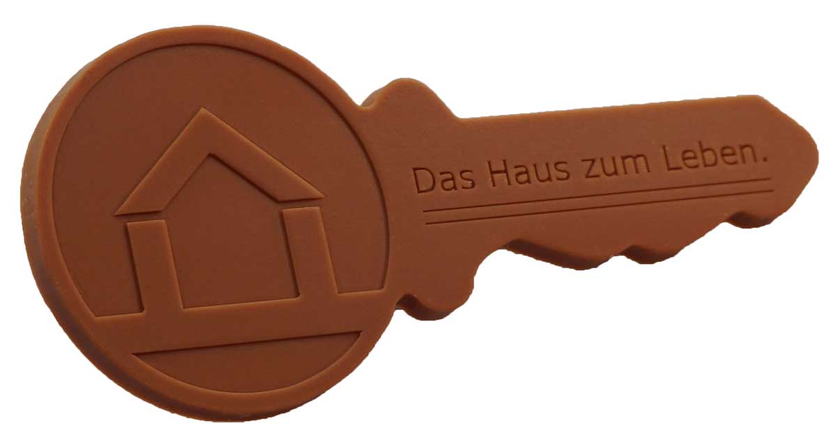 Schoko-Schlüssel Deluxe mit Haus-Logo und dem Slogan „Das Haus zum Leben“ – Werbegeschenk für Immobilienmakler