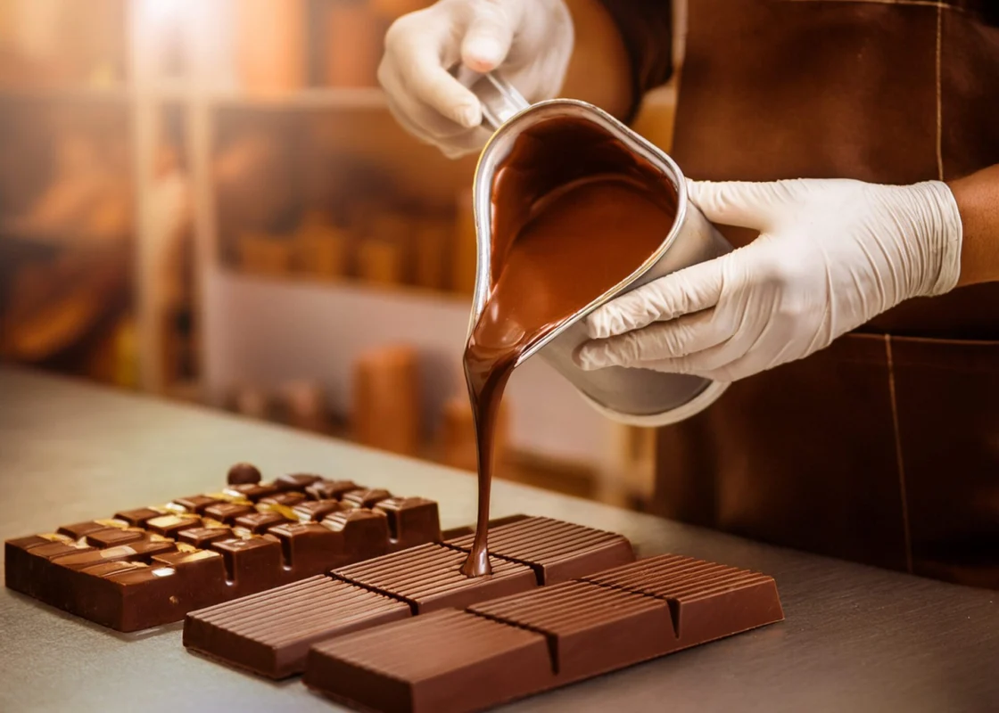 Schokologo Chocolatier gießt Schokolade